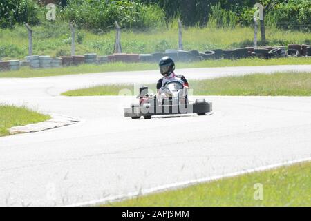 Florianopolis - Brasilien, 9. Februar 2019: Seitenansicht des Gokart-Fahrers, der an sonnigen Tagen auf der Rennstrecke fährt. Kartsport ist ein Motorsport, der in vielen Sportarten praktiziert wird Stockfoto