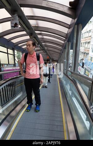 Menschen, die auf der Central Mid Level Rolltreppe, Central District, Hong Kong Island, Hong Kong Asia laufen, die längsten überdachten Rolltreppen der Welt Stockfoto