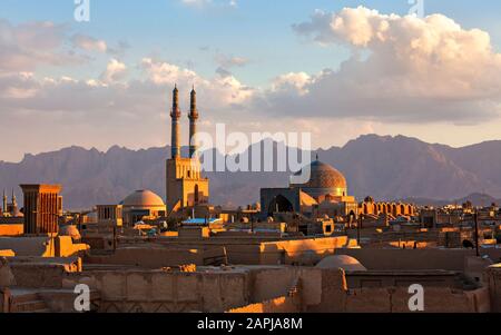 Sonnenuntergang über der Stadt Yazd mit den Minaretten und der Kuppel der Jameh-Moschee, Iran Stockfoto