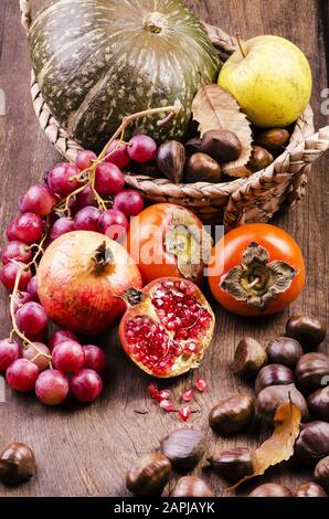 Stillleben mit Früchten und Herbstfarben auf rustikalem Holztisch Stockfoto