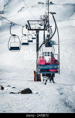 Ein Paar mit Blick auf den Skilift von hinten in Frankreich Stockfoto