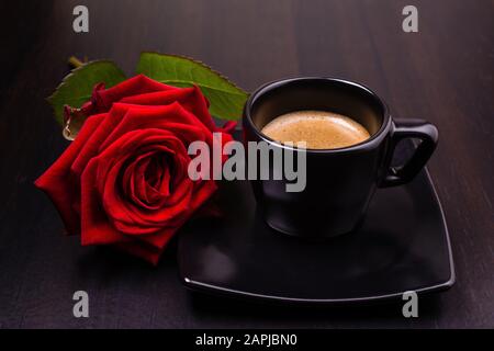 Romantisches Frühstück mit Espresso-Tasse und roter Rose Stockfoto