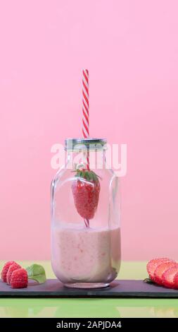 Schmackhaft aussehender Erdbeer-Milchshake in einem Glasflaschenbecher Stockfoto