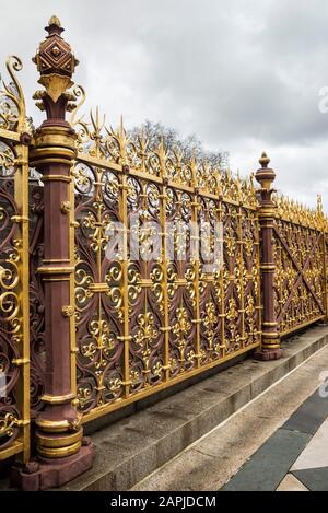 Hoch verzierte vergoldete schmiedeeiserne Zäune und Tore rund um Das Albert Memorial in Kensington Gardens, London, Großbritannien. Perspektive. Goldschmuck. Stockfoto