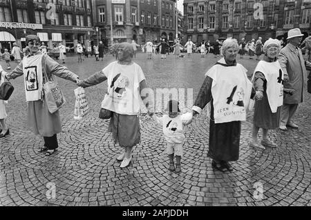 Traditioneller Friedensring am ersten Montag des Monats auf dem Dam Square in Amsterdam Beschreibung: Demonstranten mit dem Logo der Friedensbewegung auf ihrer Kleidung Datum: 1. August 1983 Ort: Amsterdam, Noord-Holland Schlüsselwörter: Anti-Atomwaffen-Bewegung, Demonstrationen, Logos, Friedensbewegung Stockfoto