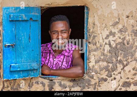 Porträt des Einheimischen in farbenfrohem Kleid, durch das Fenster, im Lake George, in Uganda Stockfoto