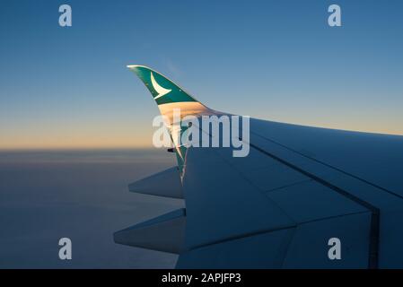 Der Sonnenuntergang scheint auf der Flügelstürze eines airbus A350-1000 von Cathay Pacific Stockfoto