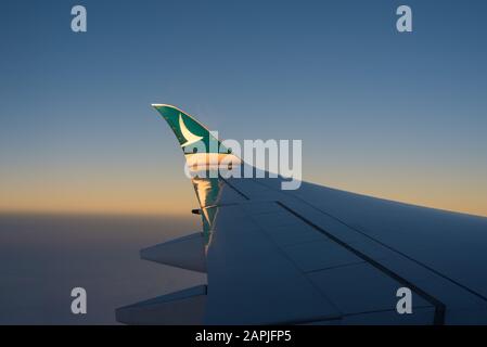 Der Flügelflitzer eines airbus A350-1000 von Cathay Pacific wird bei einem Flug nach Manila bei Sonnenuntergang beleuchtet. Stockfoto