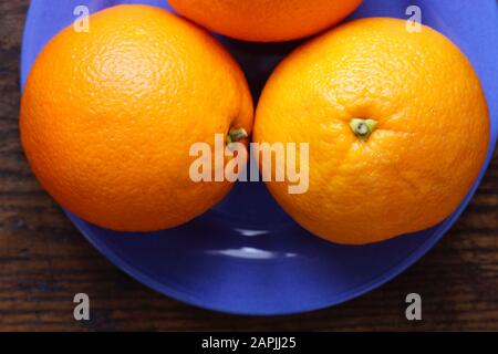 Anordnung ganzer Orangen auf dunklem Hintergrund. Kleine Gruppe von Objekten. Stockfoto