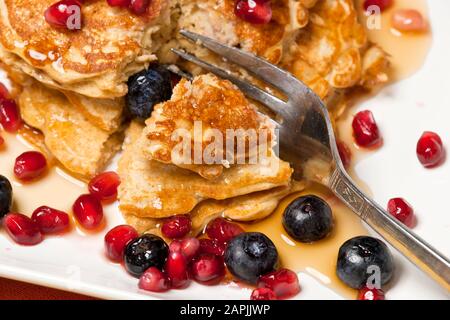 Haferbrei Pfannkuchen mit Granatapfelsamen und Blaubeeren. Stockfoto