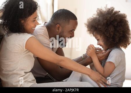 Afrikanische Familie mit kleiner Tochter, die zu Hause spielt Stockfoto