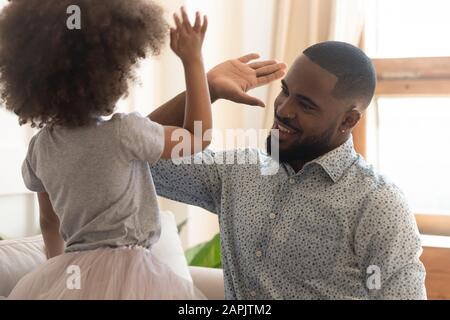 Die kleine Tochter des afrikanischen Vaters, die fünf hohe Kinder zeigt, zeigt die Zusammengehörigkeit Stockfoto