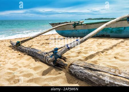 Altes traditionelles Fischerboot am Strand in Sri Lanka. Tropisches Seescape und ethnisches Urboot. Stockfoto