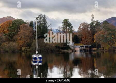 Bootshaus auf derwentwater im Herbst mit Jacht vor Anker und Katglocken im Hintergrund Stockfoto