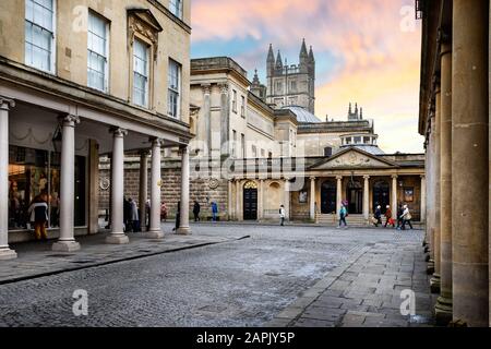 Kolonnadierte georgische Gebäude, die am 23. Januar 2020 zum Pumpenraum und zur Bath Abbey bei Sonnenuntergang in Bath Street, Bath, Somerset, Großbritannien führten Stockfoto