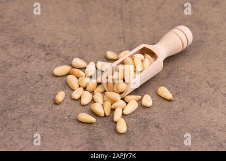 Pinienkerne auf braunem, strukturiertem Hintergrund, Nahaufnahme Stockfoto