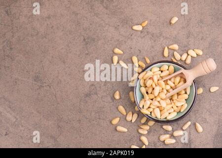 Pinienkerne auf braunem, strukturiertem Hintergrund, Nahaufnahme Stockfoto