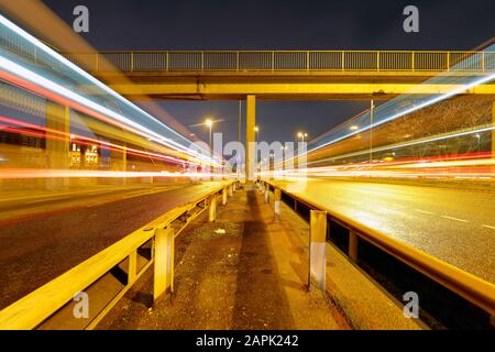 Leichte Wege von Bussen, die auf der Canal Street in Armley Leeds vorbeifahren. Stockfoto