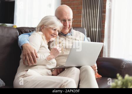 Senior Paar gemeinsam im Internet surfen. Rentner mit einem Laptop Computer zu Hause. Stockfoto