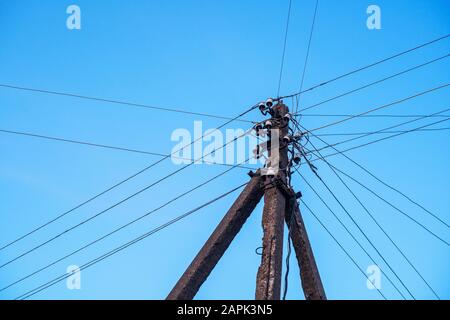 Stange mit Drähten gegen den Himmel. Hintergrund des Stromnetzes Stockfoto