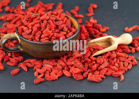 Getrocknete Goji-Beeren auf grauer Schieferplatte Stockfoto