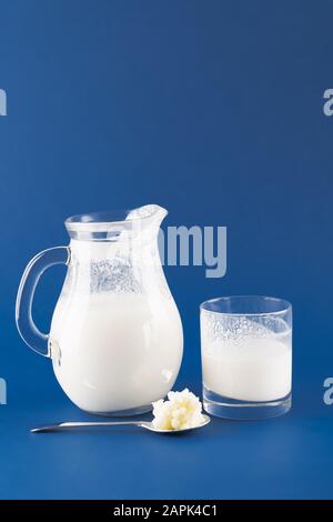 Hausgemachtes fermentiertes Getränkekefir mit Kefir Graiuns auf trendigen blauen Hintergrund, Konzept von natürlichen fermentierten Lebensmitteln und Darmgesundheit Stockfoto