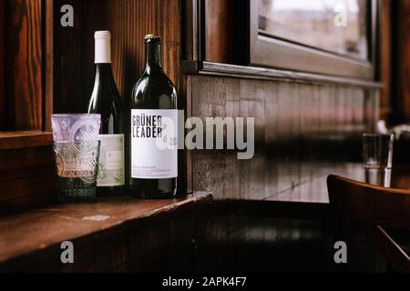 Zwei Flaschen Wein mit Gläsern auf einer Fensterbank des Restaurants. Stockfoto