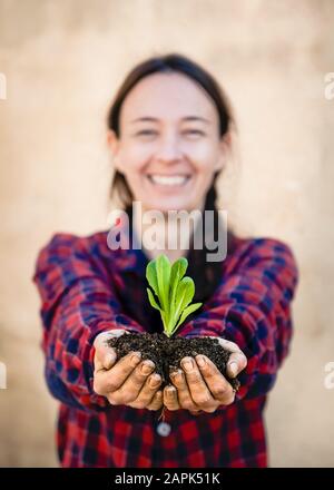 Junge Frau, die an sonnigen Frühlingstag urbane Gartenarbeit macht Stockfoto