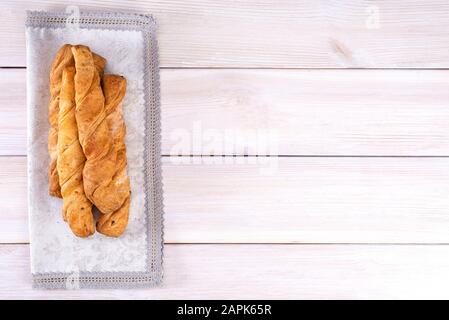 Hausgemachte frisch gebackene Brotstangen mit Blätterteig auf hellem Holzhintergrund, mit Platz für Text, Draufsicht Stockfoto