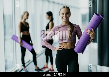 Sport fit Frau mit perfektem Körper nach dem Training stehend vor zwei fit Mädchen Stockfoto