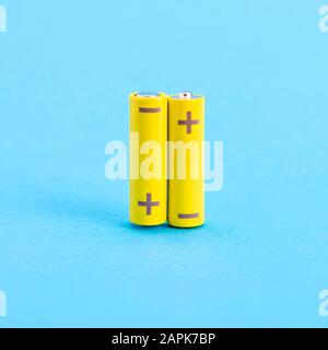 Zwei gelbe Batterien auf blauem Hintergrund Stockfoto