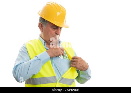 Alter Ingenieur, der Geld in der Brusttasche des Hemdes versteckt, als Bestechungskonzept isoliert auf weißem Studiohintergrund Stockfoto