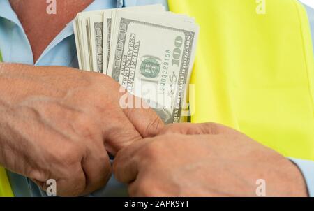 Nahaufnahme des alten männlichen Architekten, der Dollar in die Brusttasche des blauen Hemdes einsteckte, isoliert auf weißem Studiohintergrund Stockfoto