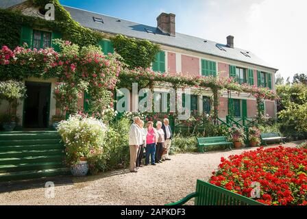 Eine Gruppe von Touristen posiert vor dem Haus von Mone in Giverny France für ein Gruppenfoto an einem sonnigen Tag Stockfoto