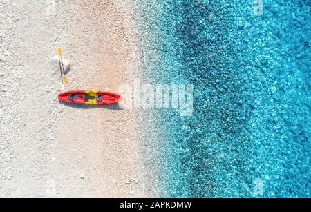 Blick auf den sandigen Strand mit farbenfrohen Kanus und blauem Meer Stockfoto