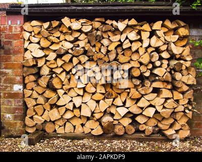 Ein gepflegter Haufen gestapelter Holzstämme, die darauf warten, bei einem Holzbrand in Großbritannien als Brennstoff verwendet zu werden Stockfoto