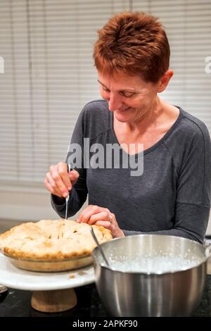 Frau schneidet Thanksgiving Dinner apfelkuchen Stockfoto