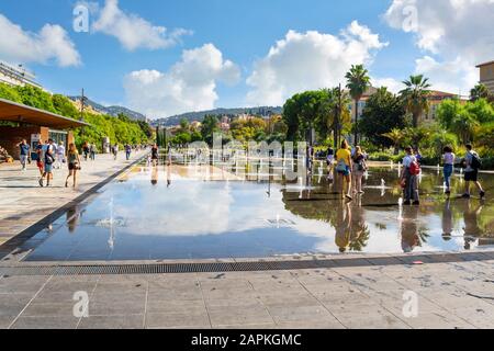 Touristen und Franzosen genießen einen sonnigen Tag an der Promenade du Paillon Water im Stadtzentrum von Nizza, Frankreich, an der französischen Riviera. Stockfoto