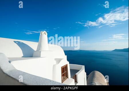 Helle abstrakte Sicht auf die weiß getünchte griechische Inselarchitektur mit einem ruhigen blauen Horizont im Mittelmeer in Santorini, Griechenland Stockfoto