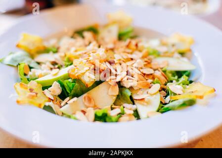 Salat mit Äpfeln, Mandeln und Kräutern im Restaurant Stockfoto