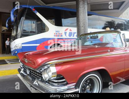 Havanna, Kuba. Februar 2016. Vor dem Fünf-Sterne-Hotel MeliÃ¡ Cohiba in Havanna, Kuba, sind ein Touristenbus und ein Cabriolet aus dem Jahr 1959 in Buick geparkt, 25. Februar 2016. Die spanische Hotelkette ist das mögliche Ziel einer Klage der Familie, die früher ein Hotel in MeliÃ¡ in der Stadt Cienfuegos besaß. Die Klage basiert auf der Entscheidung Trumps, Titel III des Burton-Helms-Gesetzes zu aktivieren, die am Donnerstag, den 2. Mai 2019 beginnt. Sie erlaubt Klagen gegen Einrichtungen, die in Immobilien tätig sind, die nach der Revolution von 1959 von der kubanischen Regierung enteignet wurden. (Credi Stockfoto