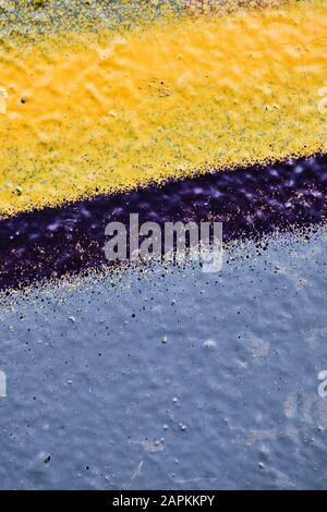 Blassblau, gelbe Farbe und violette Linie an der Wand des Putzes. Nahaufnahme. Stockfoto