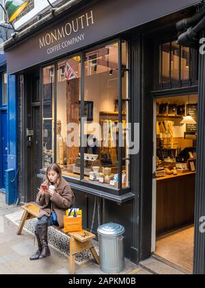 Frau Sitzt draußen, Monmouth Coffee Shop, Seven Dials, Covent Garden, London, England, Großbritannien, GB. Stockfoto