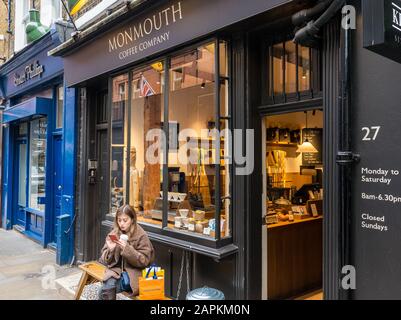 Frau Sitzt draußen, Monmouth Coffee Shop, Seven Dials, Covent Garden, London, England, Großbritannien, GB. Stockfoto