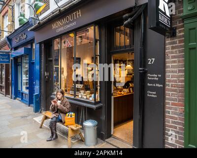 Frau Sitzt draußen, Monmouth Coffee Shop, Seven Dials, Covent Garden, London, England, Großbritannien, GB. Stockfoto