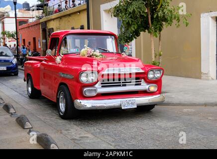 Red Chevrolet Apache Truck, Teil der Hochzeitsfeier, auf der Straße Old Colonial Old Town Oaxaca, Mexiko Stockfoto