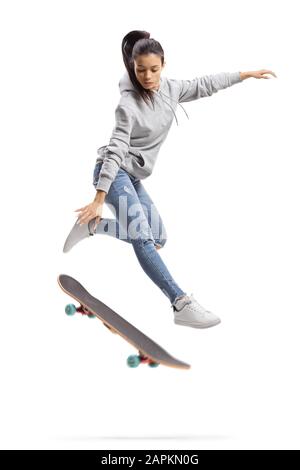 Mädchen in einem Hoodie, das mit einem Skateboard sprang, das auf weißem Hintergrund isoliert war Stockfoto