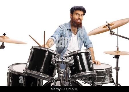 Bärtiger Drummer mit einem auf weißem Hintergrund isolierten Trommelsatz, das an der Kamera lächelt Stockfoto