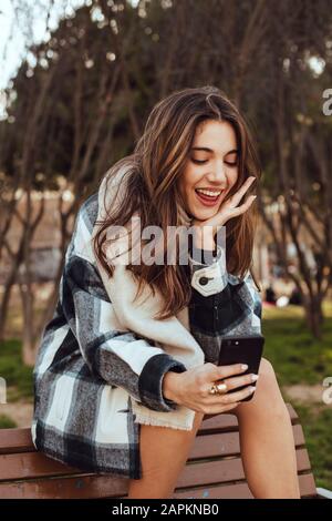 Junge brünette Frau mit Smartphone Stockfoto