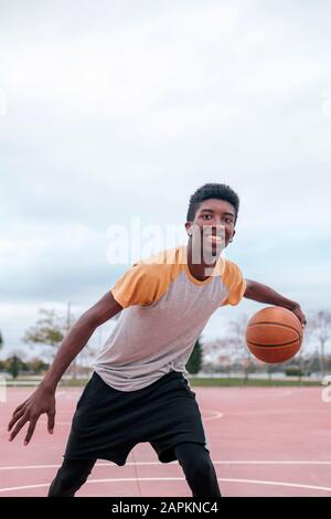 Teenager, der Basketball spielt Stockfoto